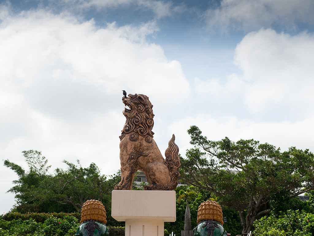 Bird taking perch on statue